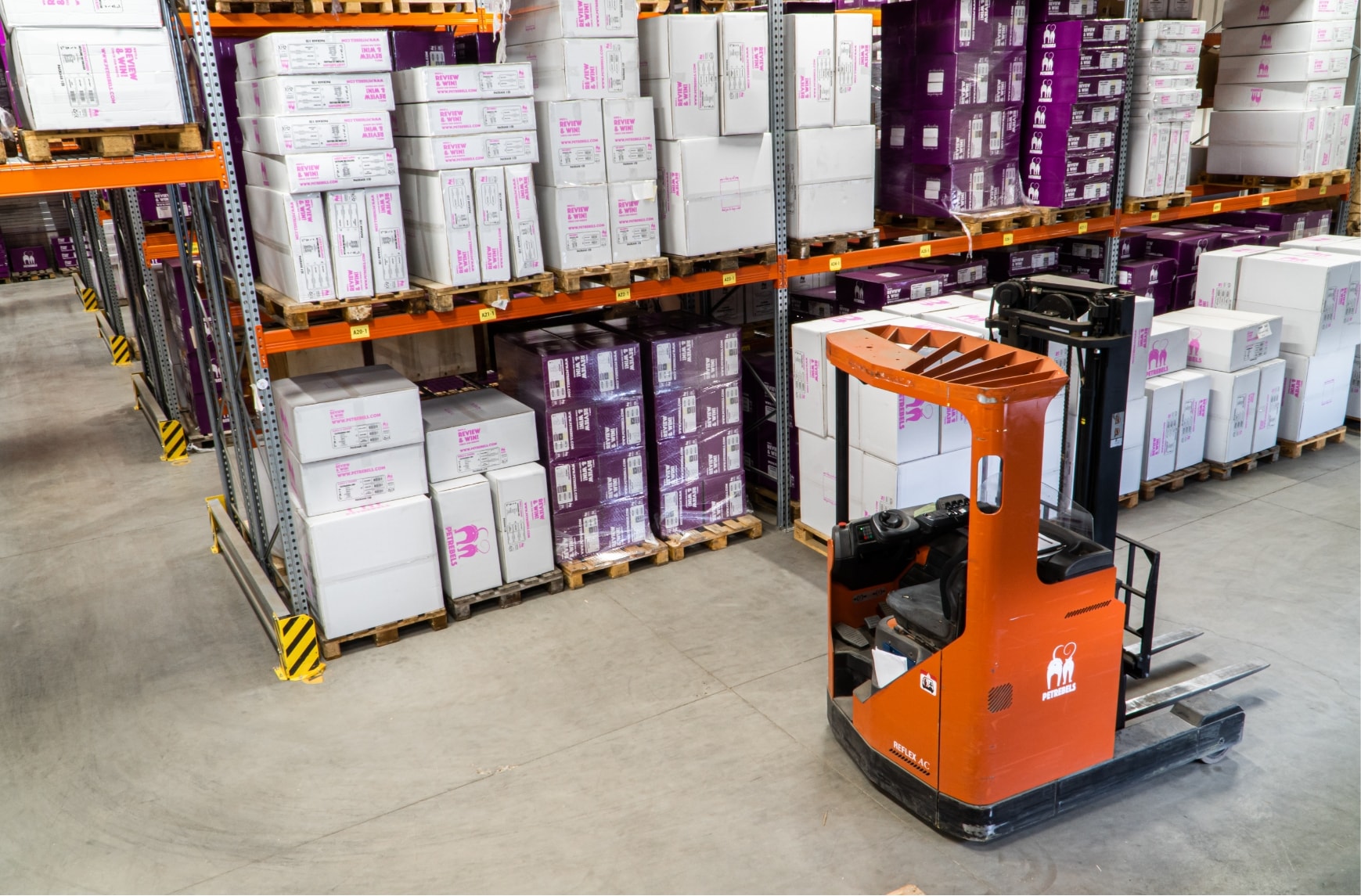 A forklift truck in the middle of a warehouse.