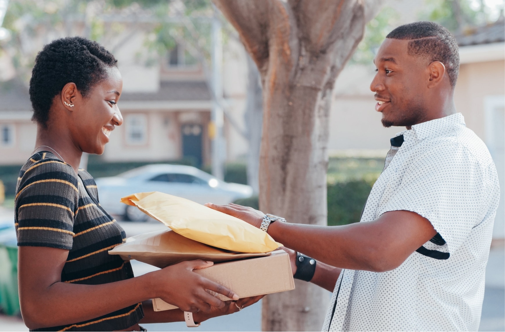 Un livreur donne trois colis à une cliente.