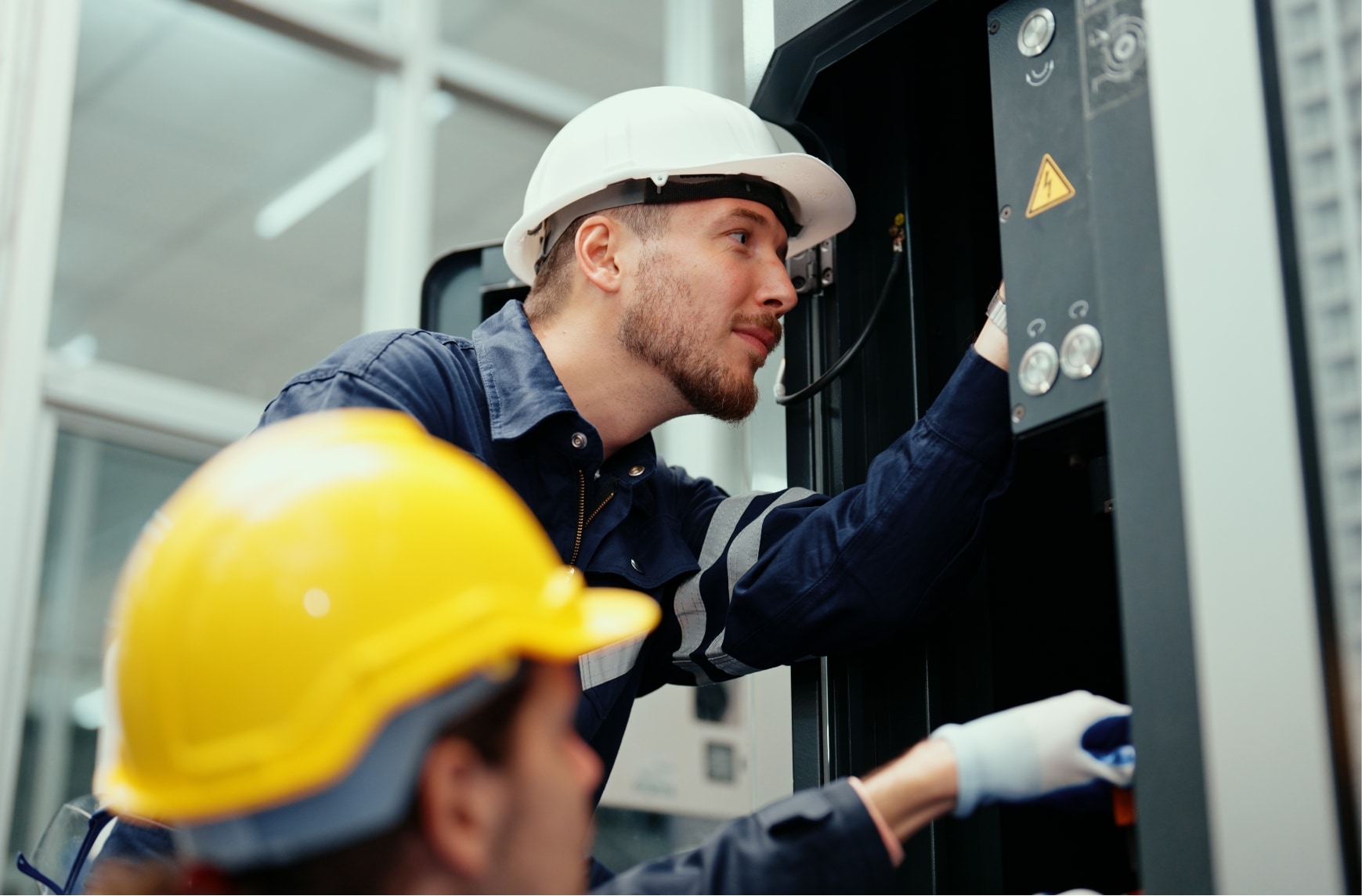 Deux techniciens inspectent une machine dans une entreprise.