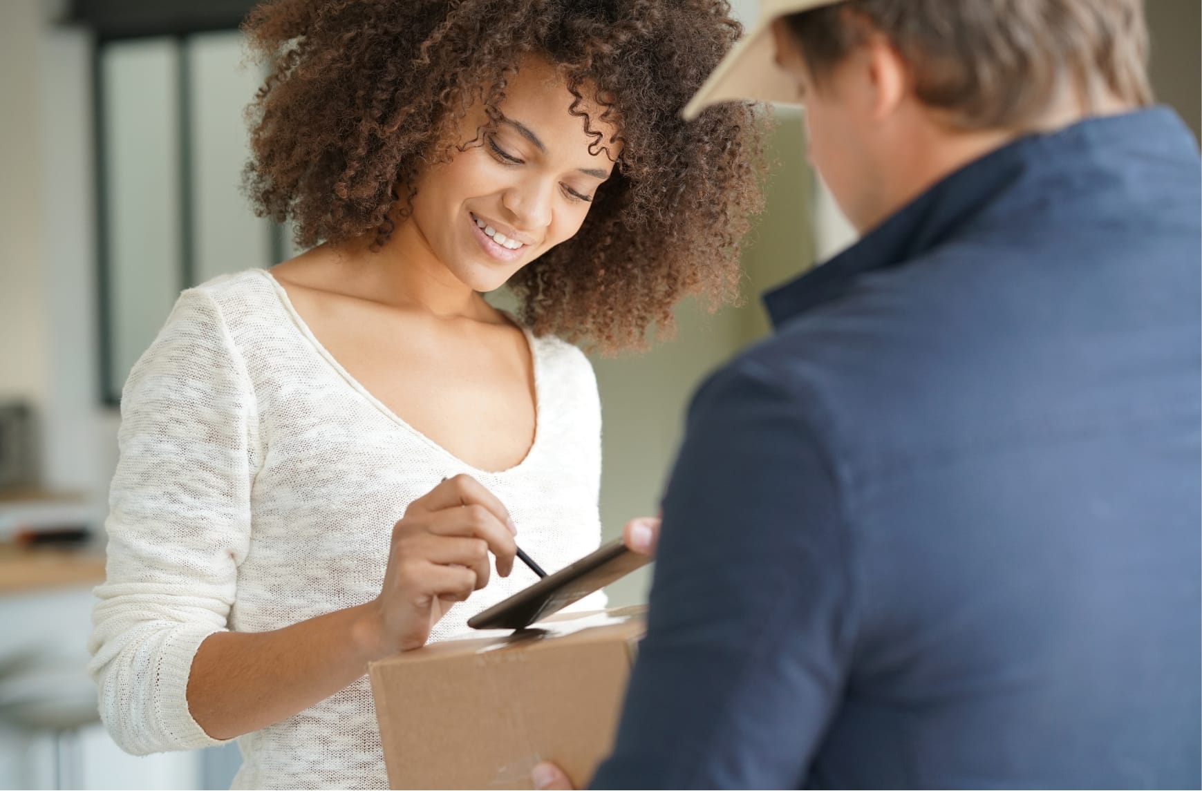 Eine Person unterschreibt den Empfang eines Pakets auf einem Smartphone.