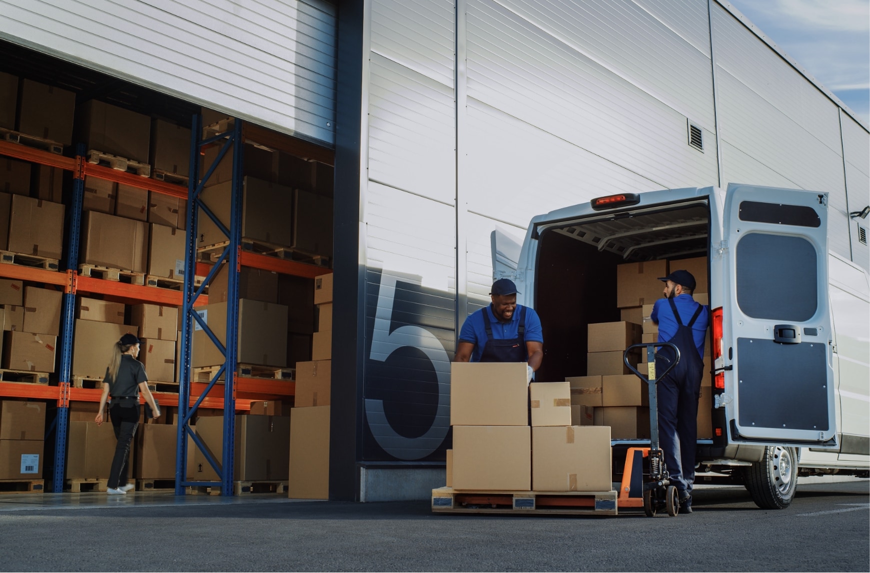 Deux hommes chargent des colis dans une camionnette.