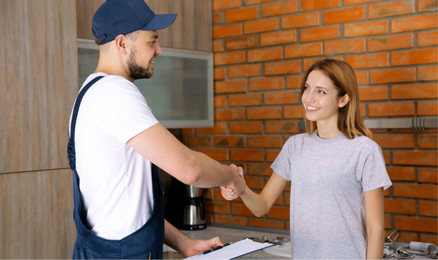 Un técnico da la mano a una persona en su casa.
