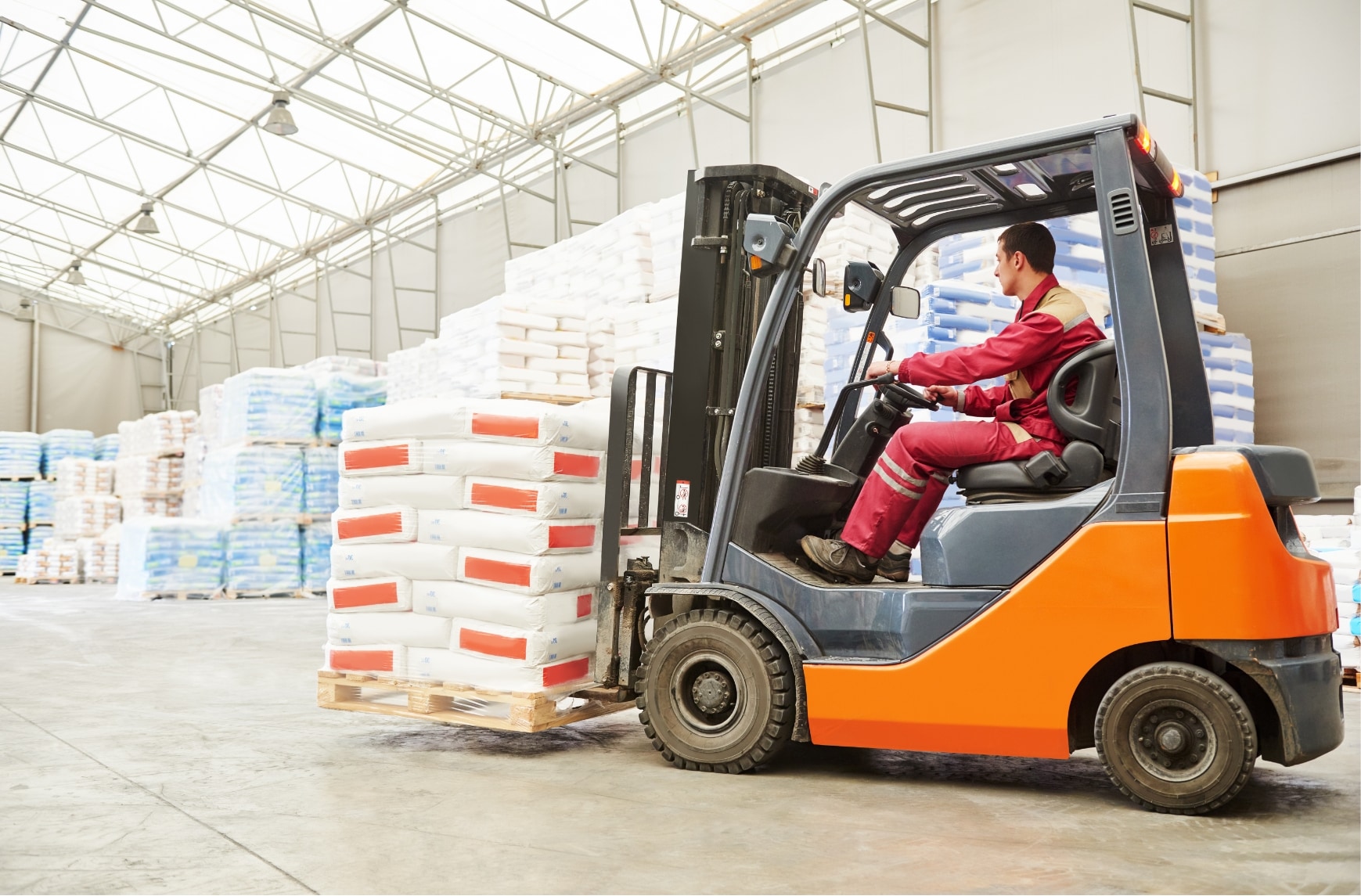Une personne utilise un chariot élévateur pour charger des matériaux dans un véhicule.